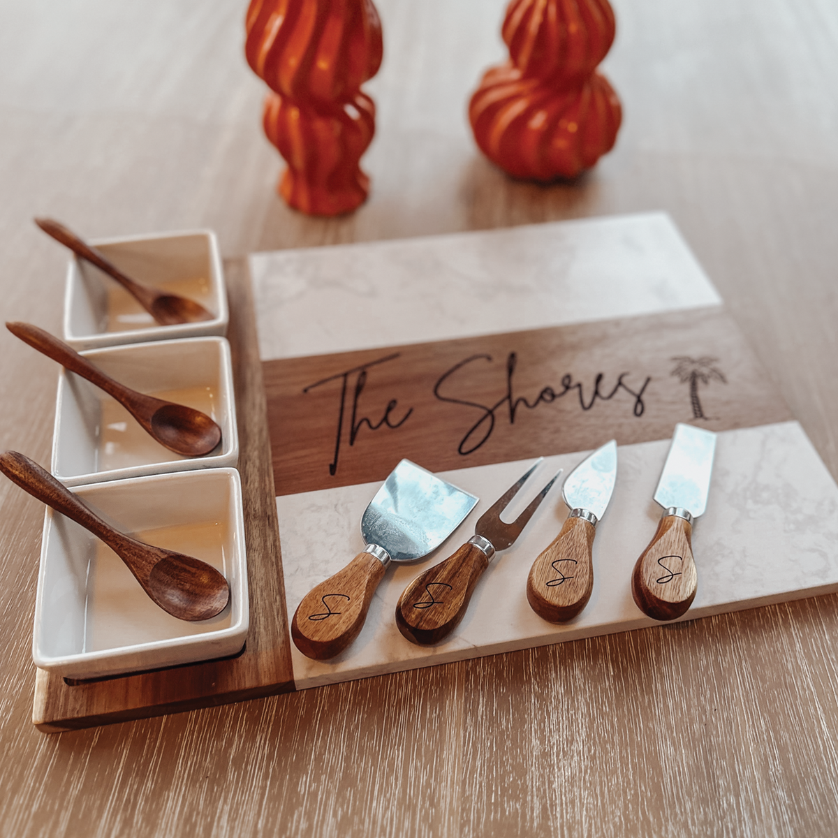 Personalized marble and acacia wood charcuterie board set with engraved wood inlay, monogrammed cheese knives, and mini sauce dishes